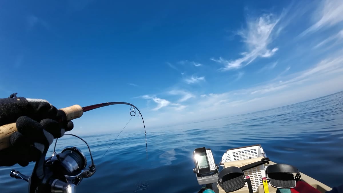 カヤックまたはSUPの上でのファイト。画面に魚探が見える写真